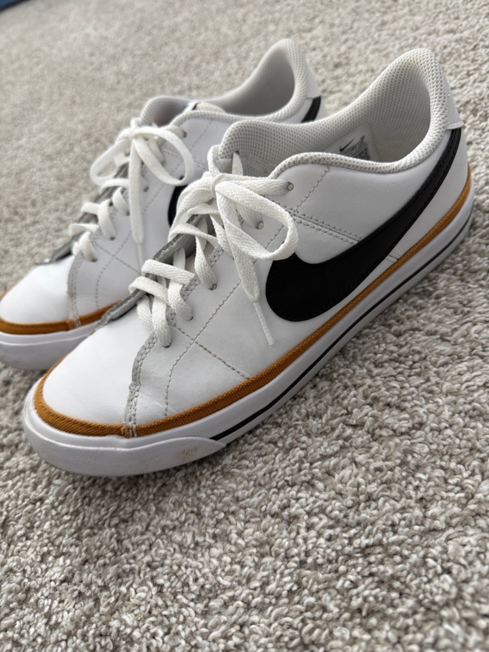 Nike White Low-Top Sneakers with Black Swoosh and Gold Trim
